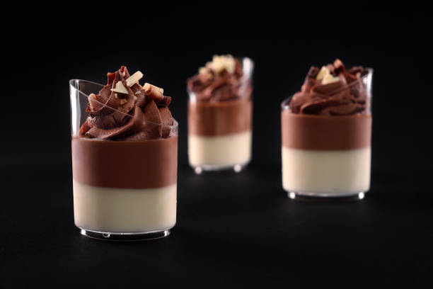 istock Glasses with layered chocolate panna cotta isolated on black. 1286685490