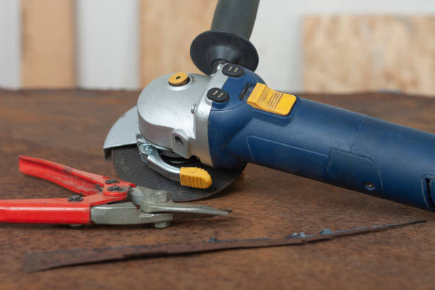 istock Angle grinder with thinner cut-off disc and red shears for cutting metal on  old rusty metal sheet. 1286686988