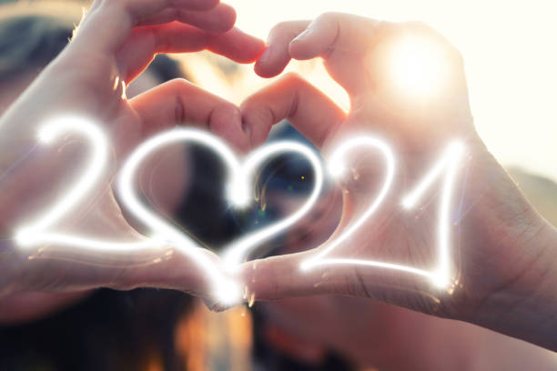 melhores namoradas fazendo mãos em forma de coração com sparkler 2021 - sparkler sparks new years eve human hand - fotografias e filmes do acervo