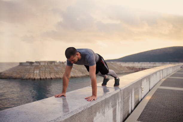 Young Man Working Push-ups By The Sea
