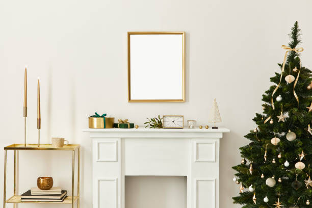 istock Christmas composition with gold mock up poster frame, white chimney and decoration. Christmas trees and wreath, candles, stars, light and elegant accessories. Template. 1286687892
