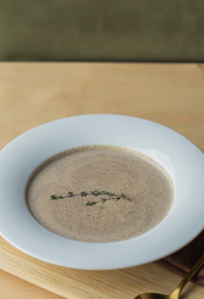 mushroom cream soup in a white  plate. cream of champignon soup - stater imagens e fotografias de stock