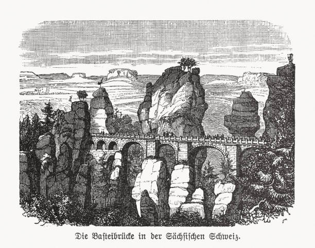 Bastei Bridge, Saxon Switzerland, Germany, wood engraving, published in 1893 Historical view of the Bastei Bridge - landmark in the Saxon Switzerland, Germany. The Bastei has been a tourist attraction for over 200 years. In 1824, a wooden bridge was constructed to link several rocks for the visitors. This bridge was replaced in 1851 by the present Bastei Bridge made of sandstone. The rock formations and vistas have inspired numerous artists, among them Caspar David Friedrich. Wood engraving, published in 1893. elbe valley stock illustrations