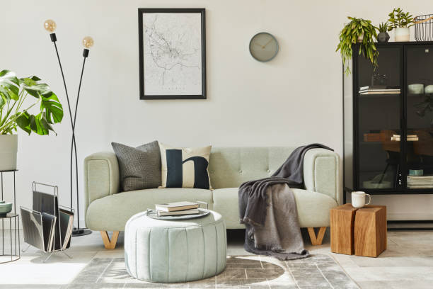 istock Unique loft interior with green comfortable sofa, design furniture, mock up poster map, carpet, plants, decoration and elegant accessories. Modern home decor in living room. White wall. Template. 1286689221