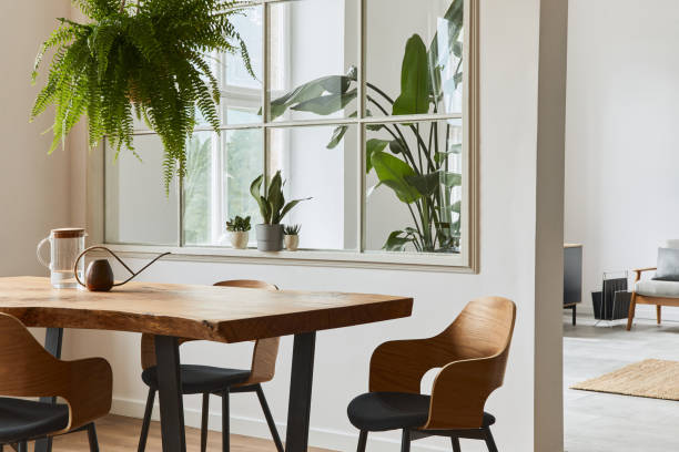 Stylish and cozy interior of dining room with design craft wooden table, chairs, plants, velvet sofa, poster map and elegant accessories in modern home decor. Template. Stylish and botany interior of dining room with design craft wooden table, a lof of plants and elegant accessories in modern home decor. Template. botanical kitchen stock pictures, royalty-free photos & images