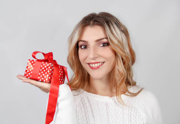 istock Smiling young woman holding Gift in hand 1286691261
