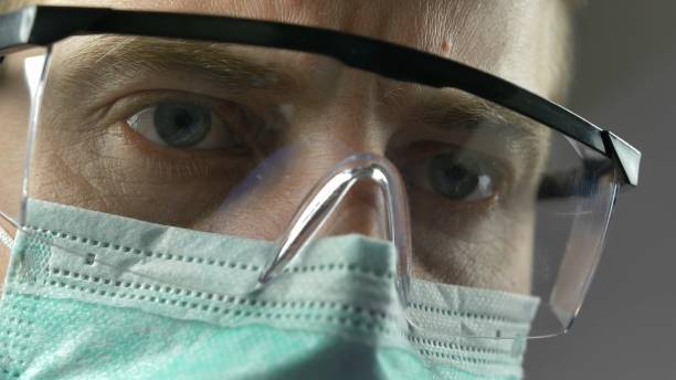 istock Doctor Performs Injection Wearing Surgical Mask Glasses and Gloves 1286691389