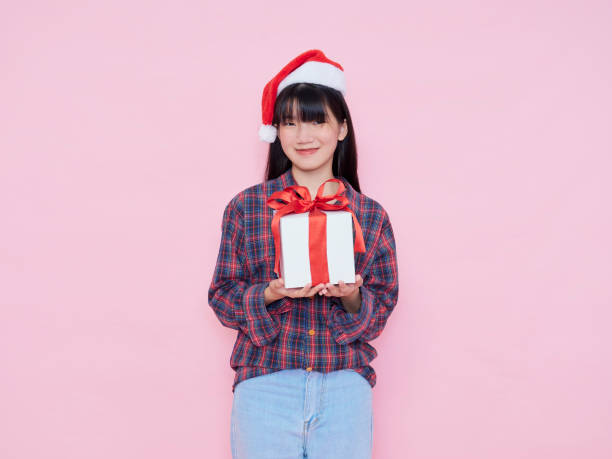 istock Smiling young woman wearing santa hat with holding gift box 1286692509