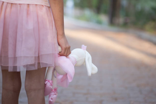 istock Soft toy rabbit in hands of girl walking in fall park 1286693014