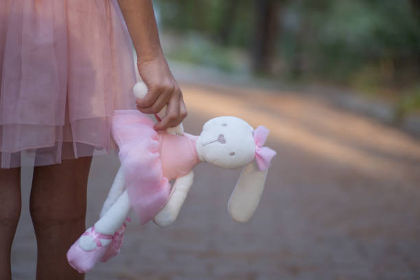 istock Soft toy rabbit in hands of girl walking in fall park 1286693016