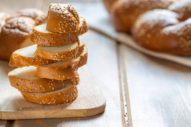 tradycyjny żydowski słodki chleb challah dla szabatu pokrojony na białej tkaninie na drewnianym stole. - hanukkah loaf of bread food bread zdjęcia i obrazy z banku zdjęć