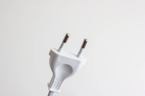 White plastic and metal pins power plug close up macro shot isolated on white.