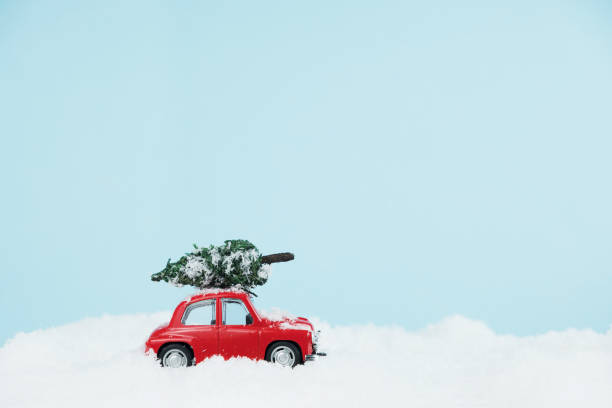 istock New Year red car with Christmas tree in a snowy landscape. Space for text 1286697505