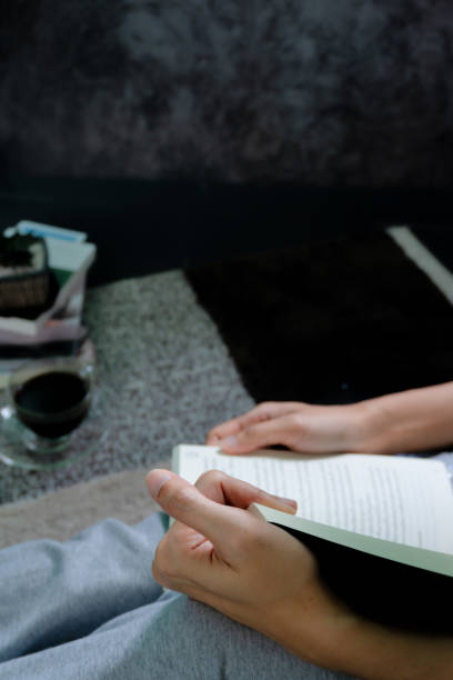 istock Woman's hand reading in a dark room, morning atmosphere with coffee. 1286698139