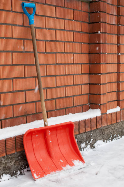 istock Snow shovel against the brick wall on a snowy yard. 1286698955