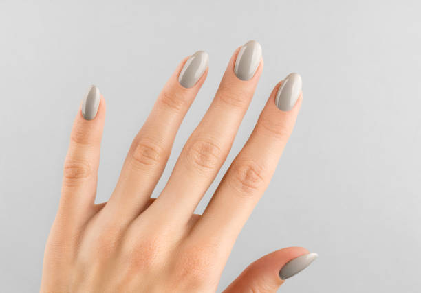 istock Beautiful womans hand with manicure close up on gray background. 1286703364