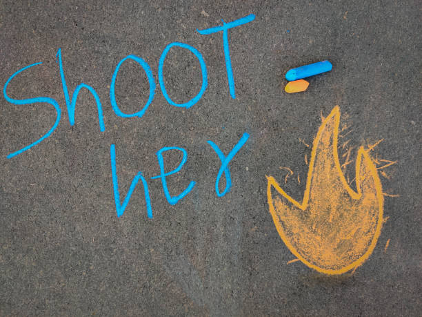 istock The inscription text on the grey board, Shoot her with fire smiley. Using color chalk pieces. 1286705979