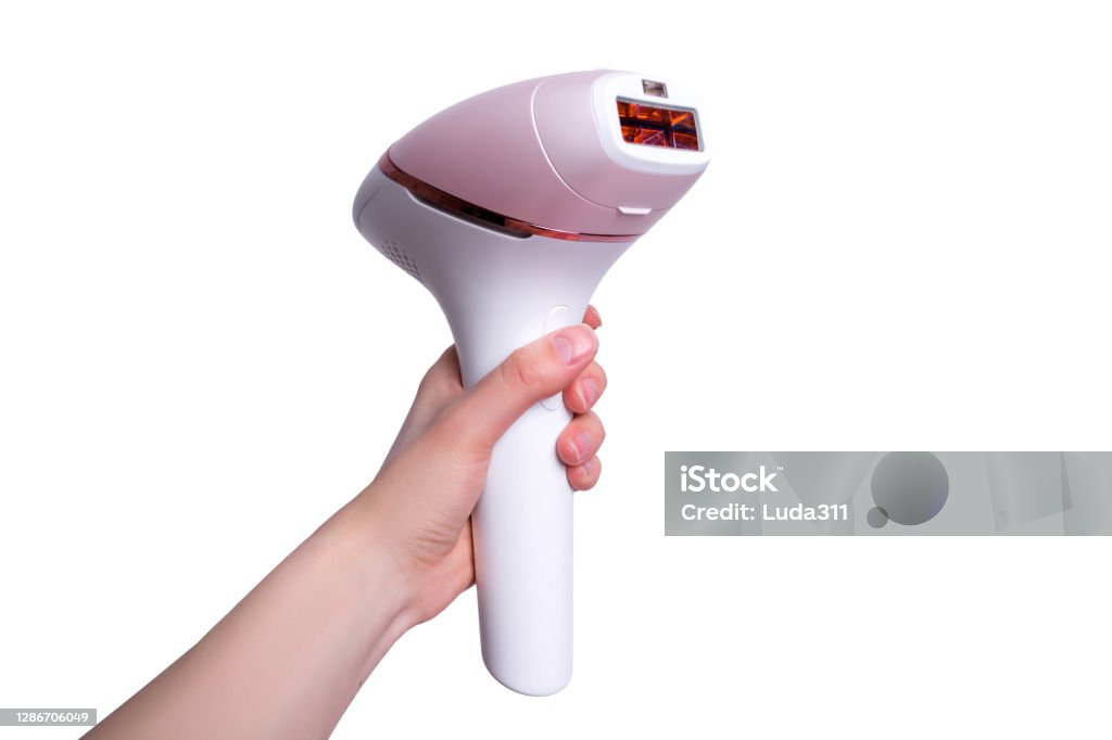 The girl holds a photoepilator in her hand. A device for removing unwanted hair isolated on white. Laser Stock Photo