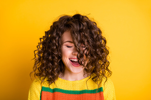 Photo of dreamy charming girl close eyes open mouth hair cover face wear striped cropped pullover isolated yellow color background.