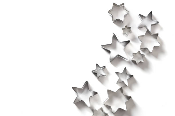 istock Christmas-themed cookie cutters stars on white. Top view. 1286709624