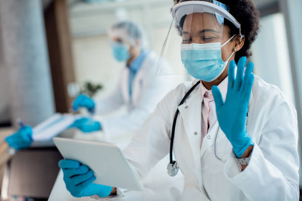 istock Happy black doctor making video call over touchpad while working at the hospital during coronavirus pandemic. 1286710601