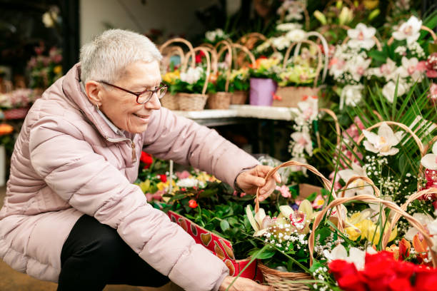 花を買う幸せな高齢の白人女性 - florist supermarket flower bouquet ストックフォトと画像