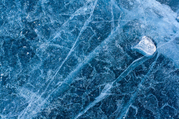 istock Amazing ice structure with cracks and air bubbles. Little melted ice floe on blue ice. Winter pattern. Horizontal. 1286713114