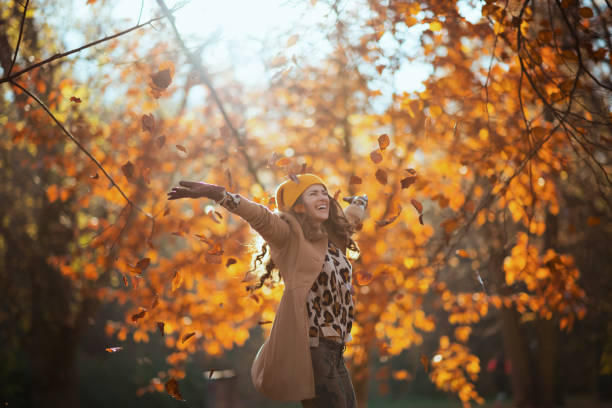 istock smiling modern female in beige coat and orange hat rejoicing 1286713127