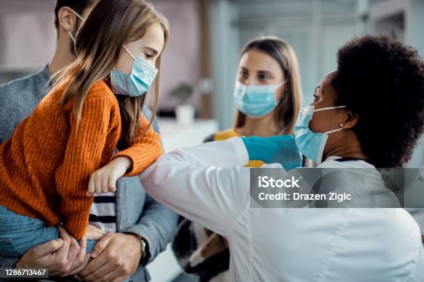 Meisje En Afrikaanse Amerikaanse Vrouwelijke Artselleboog Die Bij Medische Kliniek Stoten Stockfoto en meer beelden van Ziekenhuis