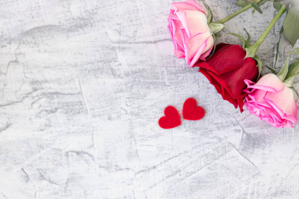 istock Two red hearts and three rose on a stone white background. Romantic gift for Valentine's day. Love. Soft focus. Copy space. 1286713775