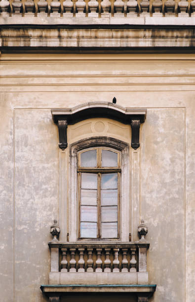 istock Antique baroque window framed by decorative stucco with a balustrade below on a gray wall. Dominican Cathedral Monastery. Lviv, Ukraine. 1286720602