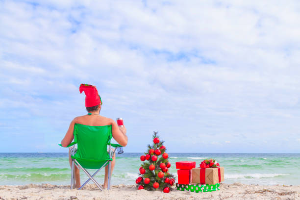 istock Young man enjoying his holidays vacations at Miami Beach, Florida, USA, having fun, drinking a beer, sit and looking in front of the see 1286723092