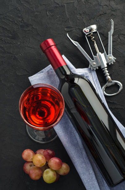 istock Wineglass and bottle with wine on dark background 1286723663