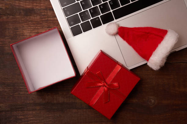 istock Online shopping for Christmas, a computer on a wooden table next to a gift 1286724310