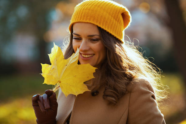 istock smiling modern female in brown coat and yellow hat 1286727670