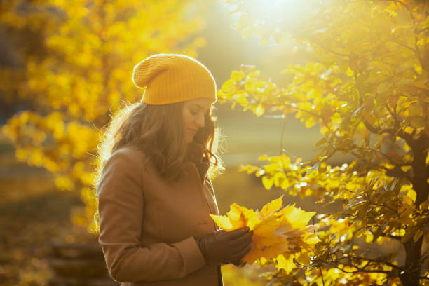 istock pensive elegant woman in beige coat and orange hat 1286729018