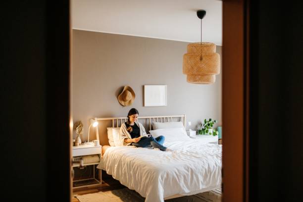 istock Young woman reading a book on a bed 1286730394