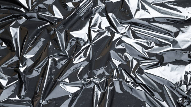 istock Plastic wrap. Black shiny film bag pattern. Transparent dark cellophane texture. Creative crumpled background. 1286730575