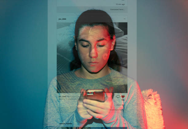 The Social Media Overuse A 13-year-old girl is using her smartphone in the dark room. The content she is browsing projects over her face and wall behind her. social media kids stock pictures, royalty-free photos & images