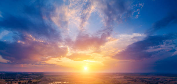 istock Spring rural landscape in the evening with a beautiful burning sky, aerial view. Panoramic view of pine forest, fields, and river during blazing sunset 1286737385
