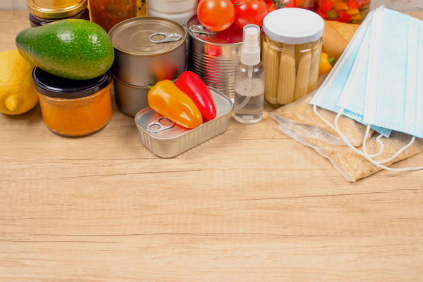 istock Different food and medicines donations on wooden table background with copyspace - pasta, fresh vegatables, canned food, disposable face masks, sanitizer. Food bank or delivery concept 1286742502