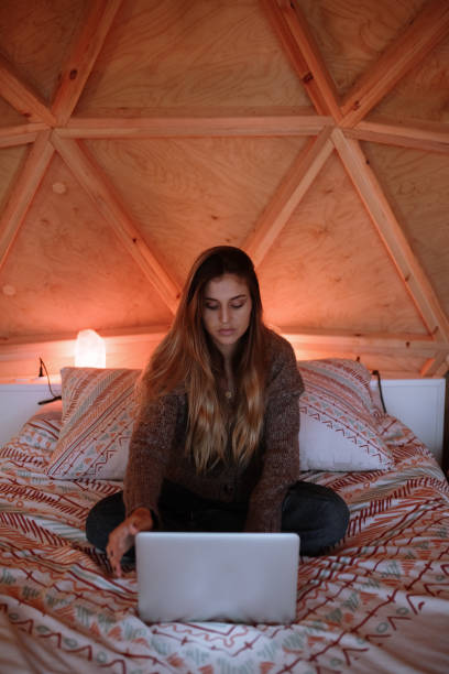 istock Young woman using a laptop in a bed 1286742534