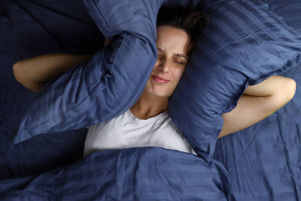istock angry irritated girl covered her ears with pillows 1286745071
