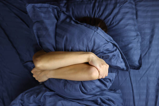 istock Young girl sleeping hugging a pillow 1286745741