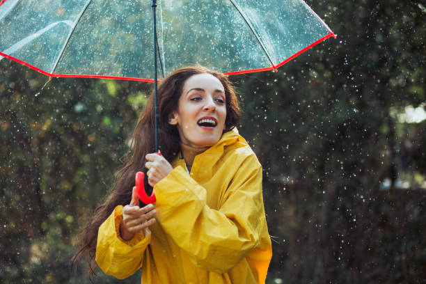 istock Joyful woman walking in rainy weather 1286745952