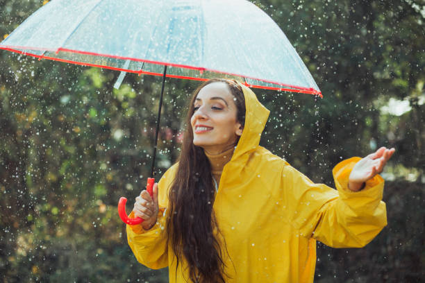 istock Joyful woman walking in rainy weather 1286745965