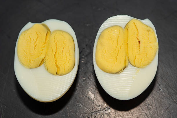 un œuf avec deux jaunes. double jaune d’œuf dur. plan rapproché d’un oeuf avec deux jaunes - two eggs photos et images de collection