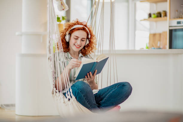 istock Young woman is relaxing at home while reading a book 1286753370