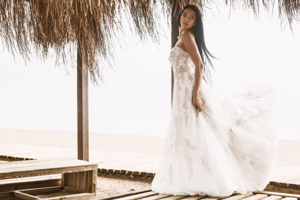 istock Young beautiful bride standing in the gazebo by the beach. 1286753483
