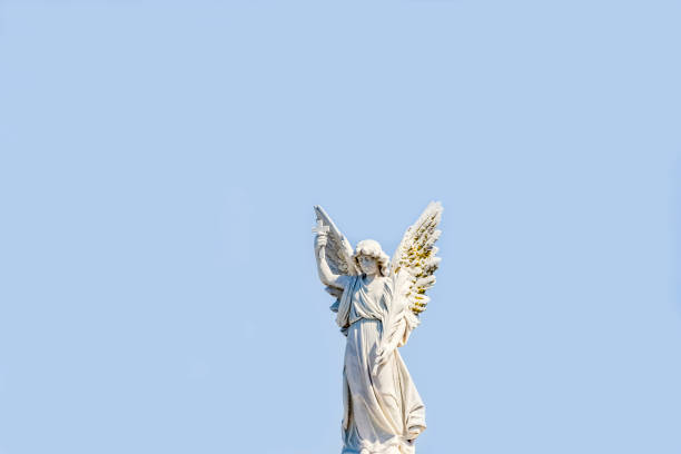 istock Angel, old statue of angle with cross, blue sky background with copy space 1286754426